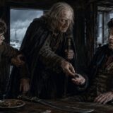 Three rugged men in a dark, old tavern; a standing man offers a coin to a seated, scarred elder while another man grips his arm.