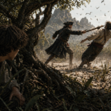 A man crouches under a tree in a swamp as two others chase toward the water, birds flying overhead in a tense scene.
