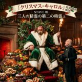 Banner above reads 'クリスマス・キャロル': Santa sits on a throne in a green velvet robe with white trim, holding a torch amid a lavish Christmas feast and fireplace scene, as an elderly man in a dark coat looks on.