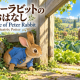 青い上着を着た子うさぎピーターが、マグレガーさんの野菜畑の木の門の下で身をかがめている。『ピーターラビットのおはなし』の表紙。