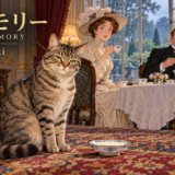 英国の屋敷のお茶会で、ミルクの皿のそばに悠然と座る猫トバモリーと、驚く招待客たち。
